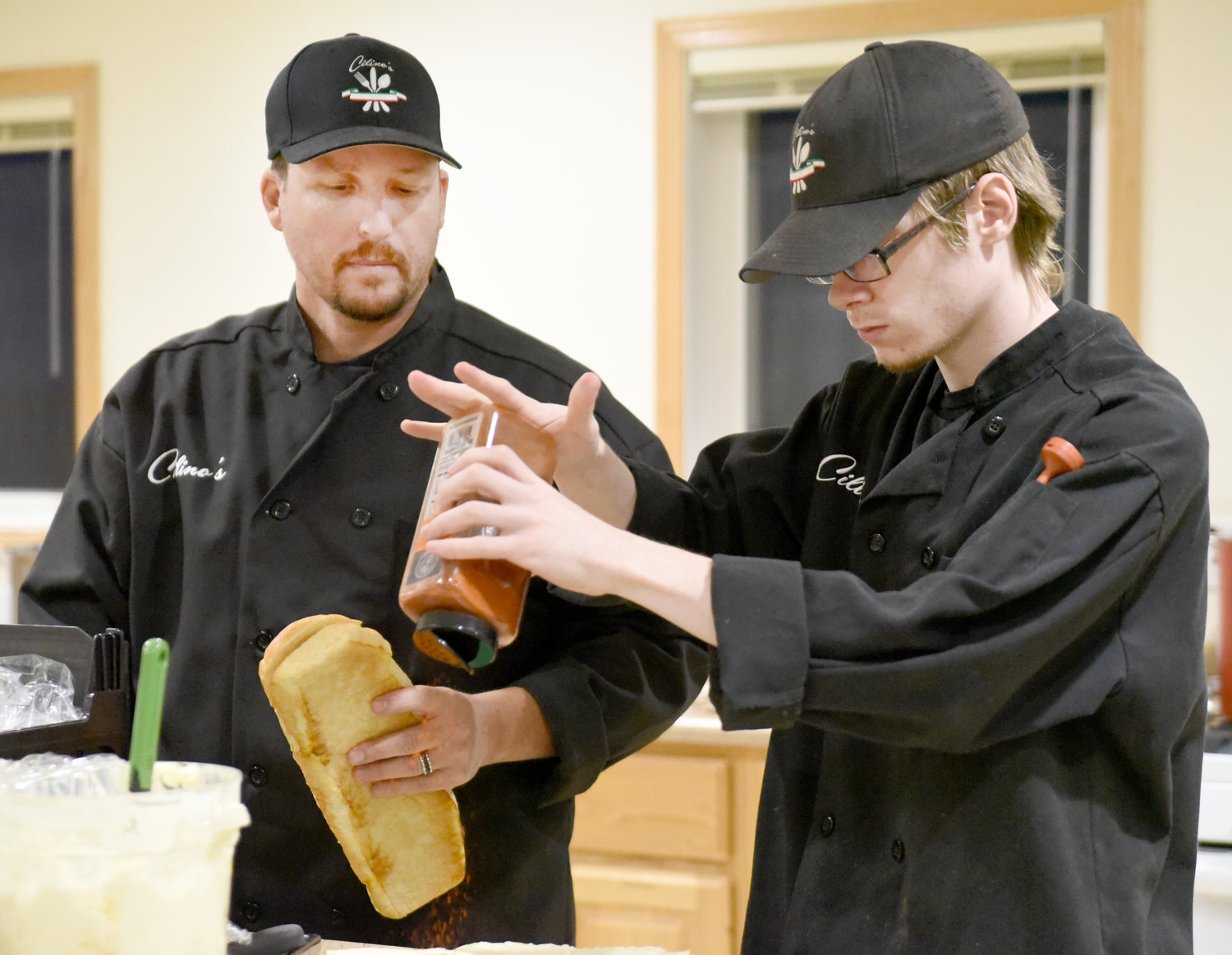 Chef Randy Rodgers of Cilino’s restaurant of Wellman watches cook Tyson Nuezil, 21, put the finishing touches on the garlic bread before serving a five-course meal at the Washington County Community Foundation’s Chef Spotlight dinner on Nov. 4.  A dessert auction, featuring Dwight Duwa, benefitted both the foundation and the Kalona Historical Village.